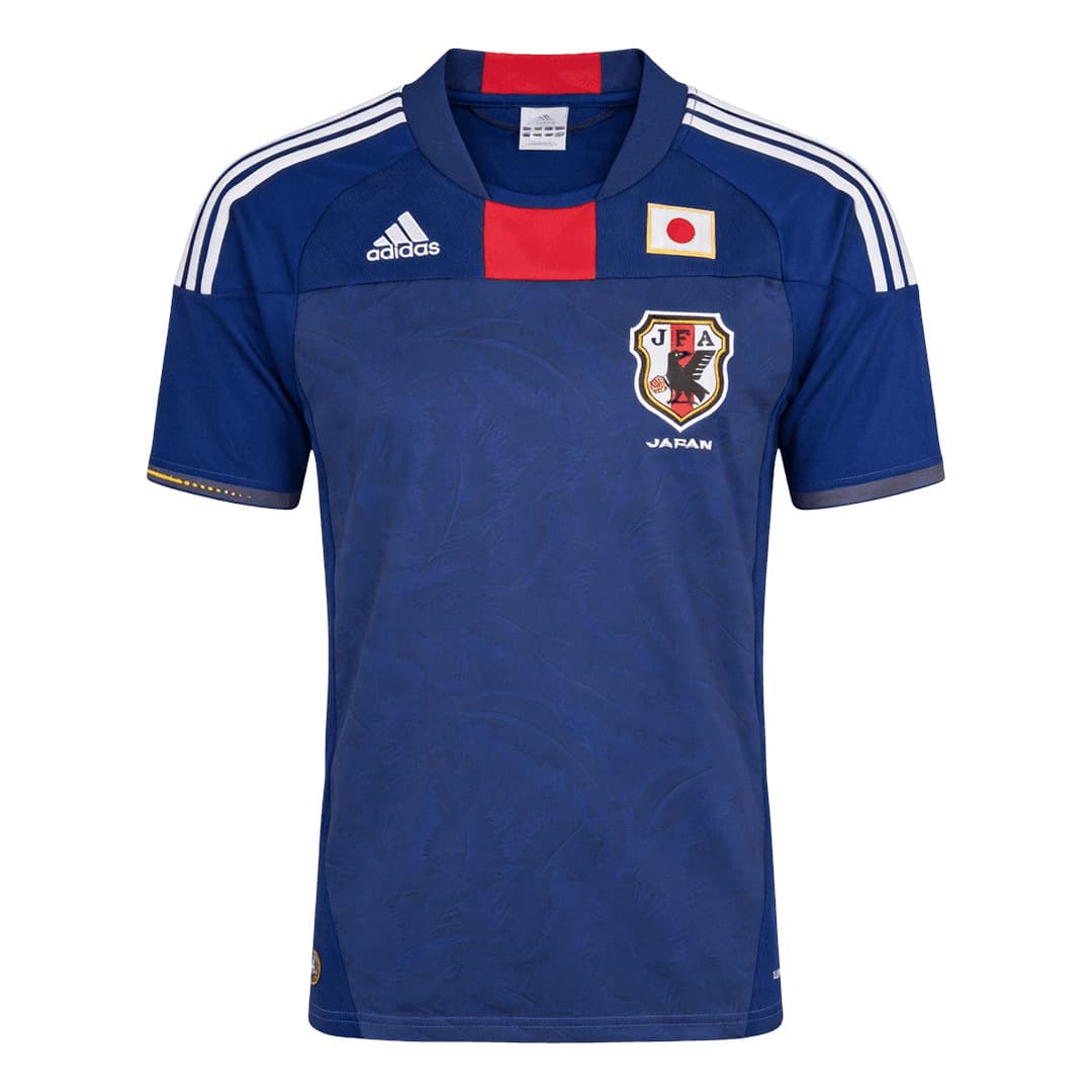 Japan 2010 home shirt, front: deep blue with a tonal feather pattern, a red block beneath the collar, white adidas stripes, the JFA crest and the Japan flag.