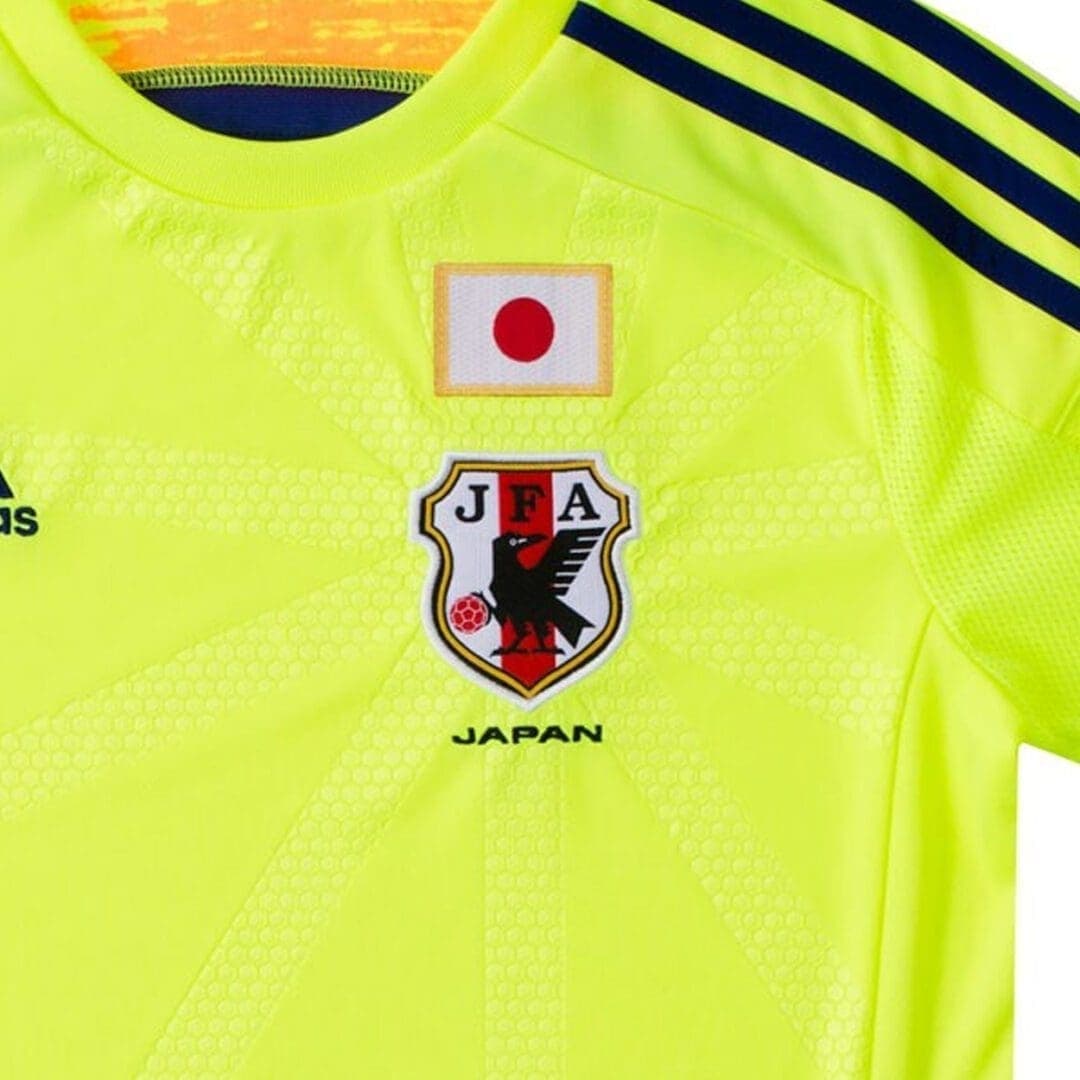 Detail of the Japan 2014 away: the Japan flag and JFA crest on the volt-yellow body.